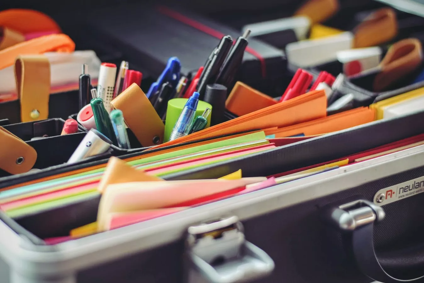 Geöffneter Koffer mit Stiften, Scheren und bunten Moderationskarten für Workshops